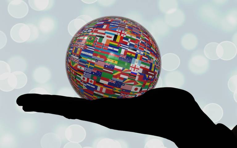 Image of hand holding an image of the world (globe)