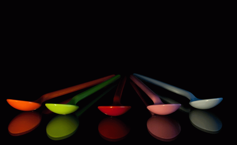 image: brightly coloured spoons on a black background