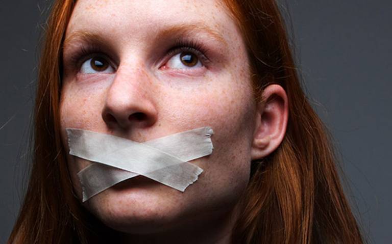 Image: young woman with tape across her mouth