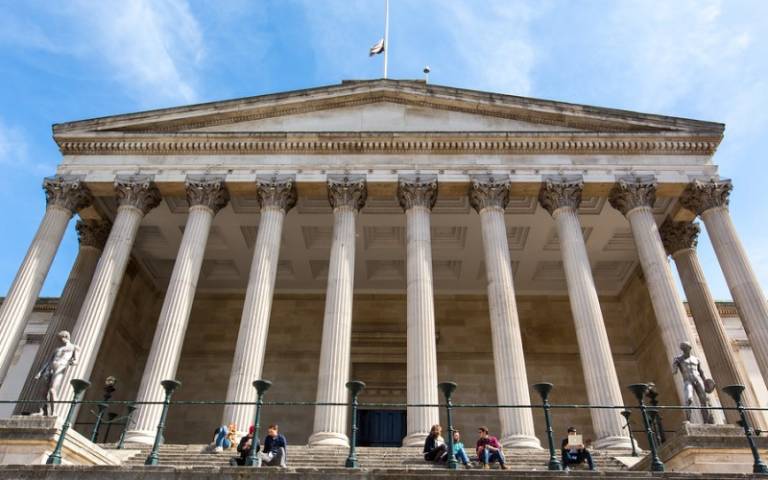 Students sitting in small groups on the steps outside the UCL Portico building