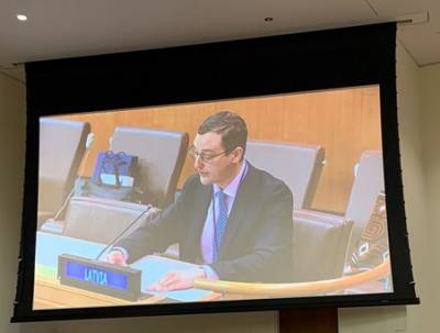 Dr Martins Paparinskis delivering a statement at the UN General Assembly’s Sixth Committee. Dr Paparinskis is sitting and speaking into a microphone behind a sign reading "LATVIA".