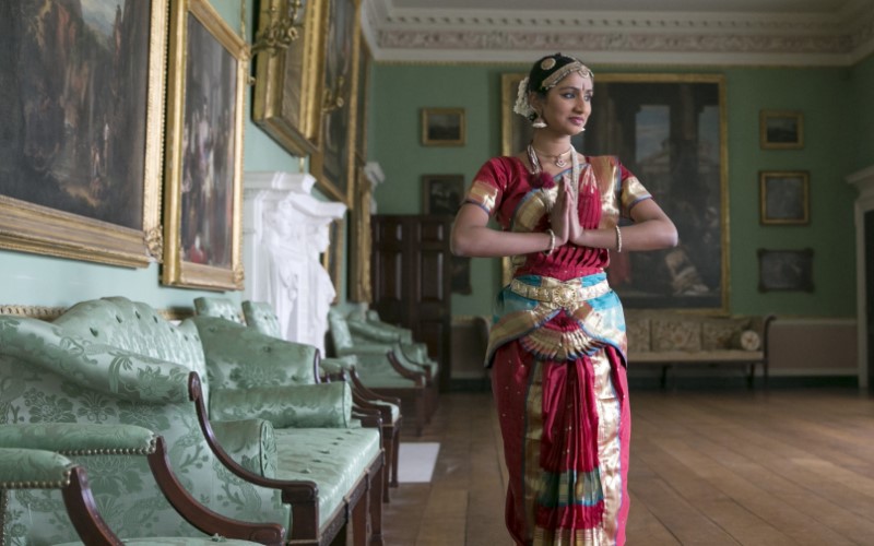 Dancer in Asian clothing dancing in a historic house