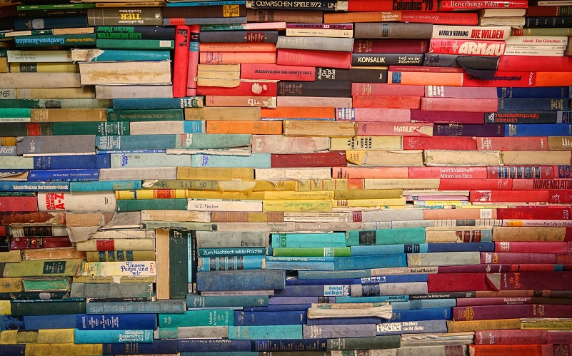 Stacks of colourful books, by Robert Anasch