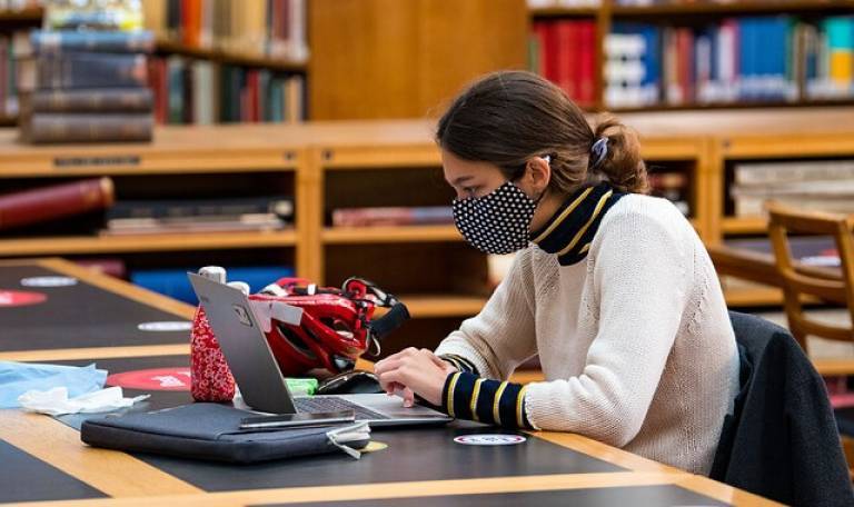 Library user sat at a desk, wearing a protective mask