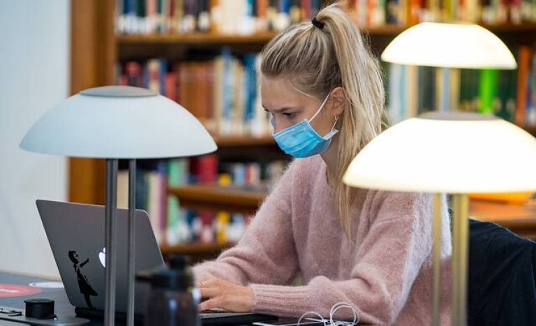 Library user studying, wearing a face mask