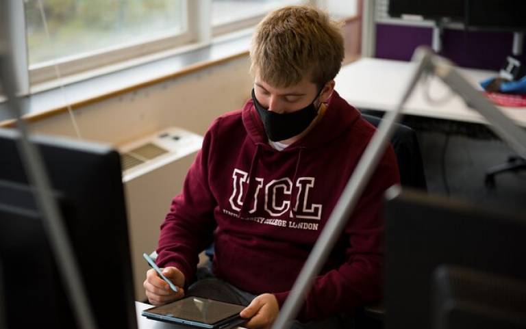 Male student at desk, wearing a mask