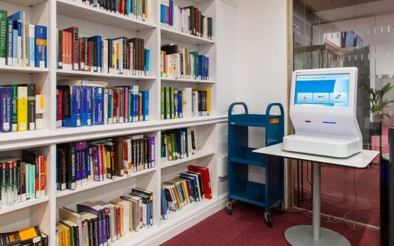 Books on shelves next to a self-issue machine