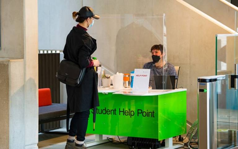 Student being assisted at the student help point desk inside the Student Centre