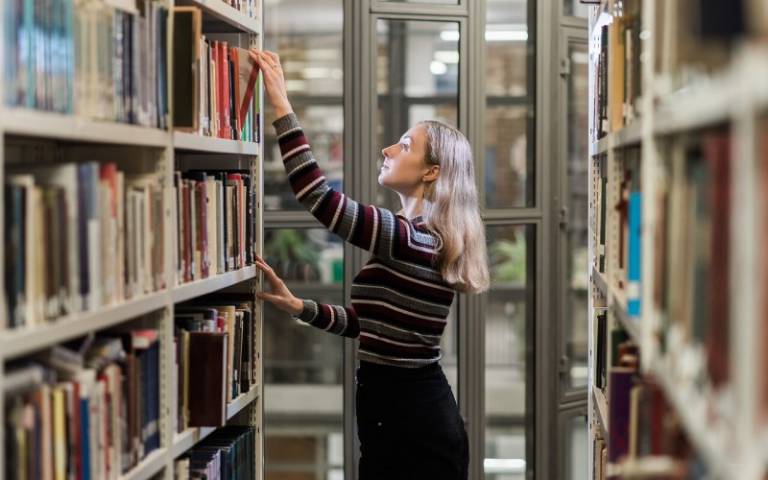 User taking an item from a shelf in the UCL School of Slavonic and East European Studies Library
