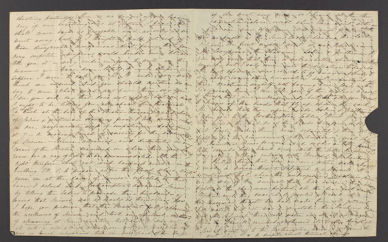 A handwritten letter. A letter has been written horizontally on a large sheet of paper. A different hand has written a reply vertically on top of the letter. The handwriting is difficult to read and the layers create a crisscross pattern.