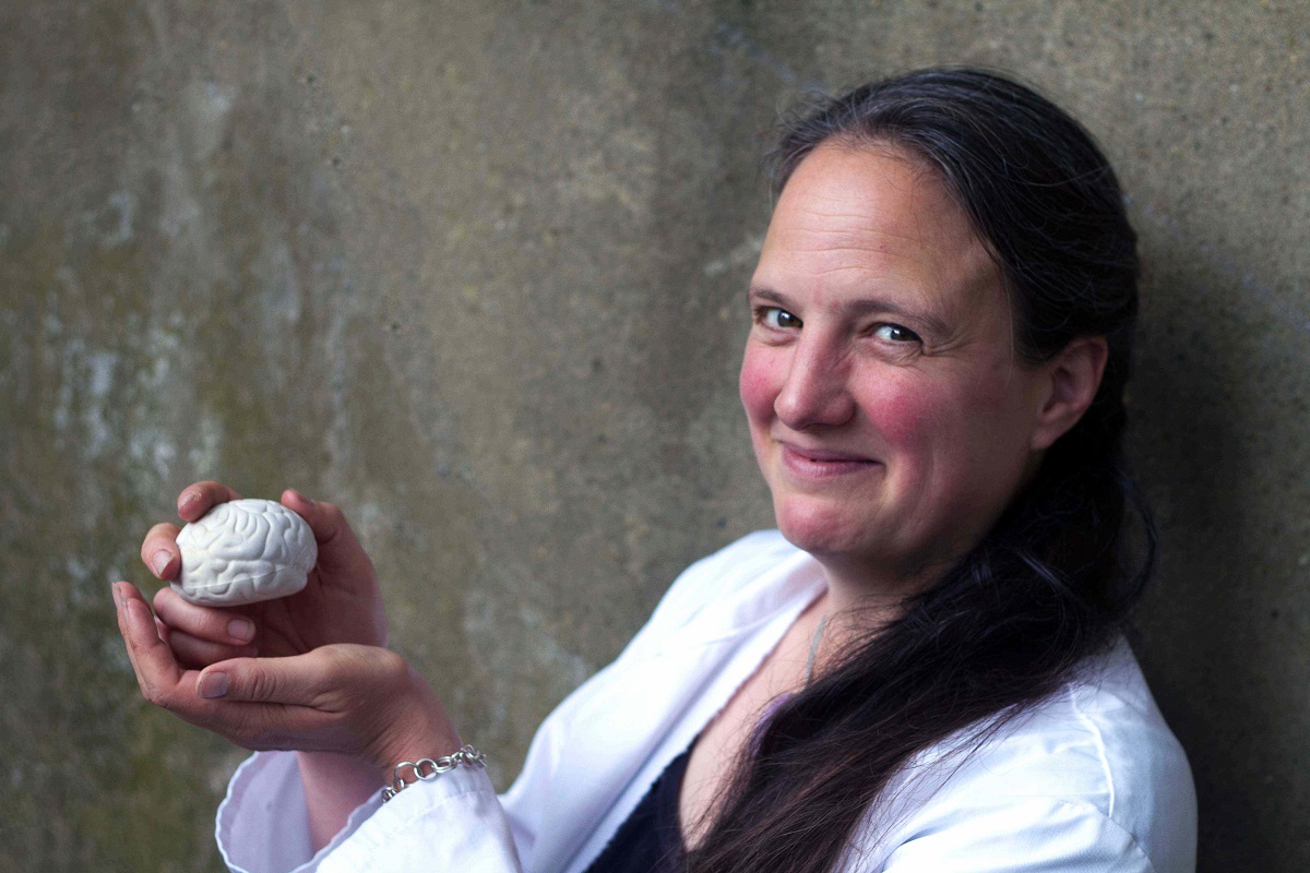 Professor Stephanie Schorge holding a brain.