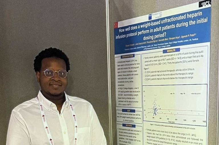 Osama Fallatah standing in front of his research poster that displays his work. 