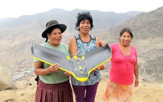three Peruvian women with landscape in the background