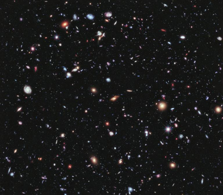 In this image — one of the deepest ever taken by the Hubble Space Telescope — most of the luminous sources are distant galaxies. The expansion of the Universe causes a cosmological redshift, so that the most distant sources appear reddest. The work …