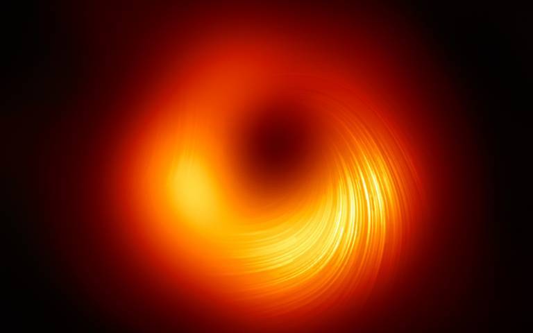 A view of the M87 supermassive black hole in polarised light. The lines mark the orientation of polarisation, which is related to the magnetic field around the shadow of the black hole. Credit: EHT Collaboration