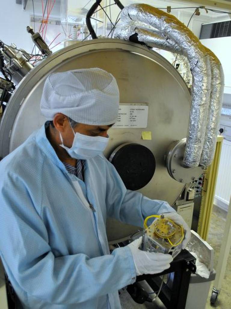 Dhiren Kataria (MSSL) holds a CubeSat chassis in front of a vacuum chamber