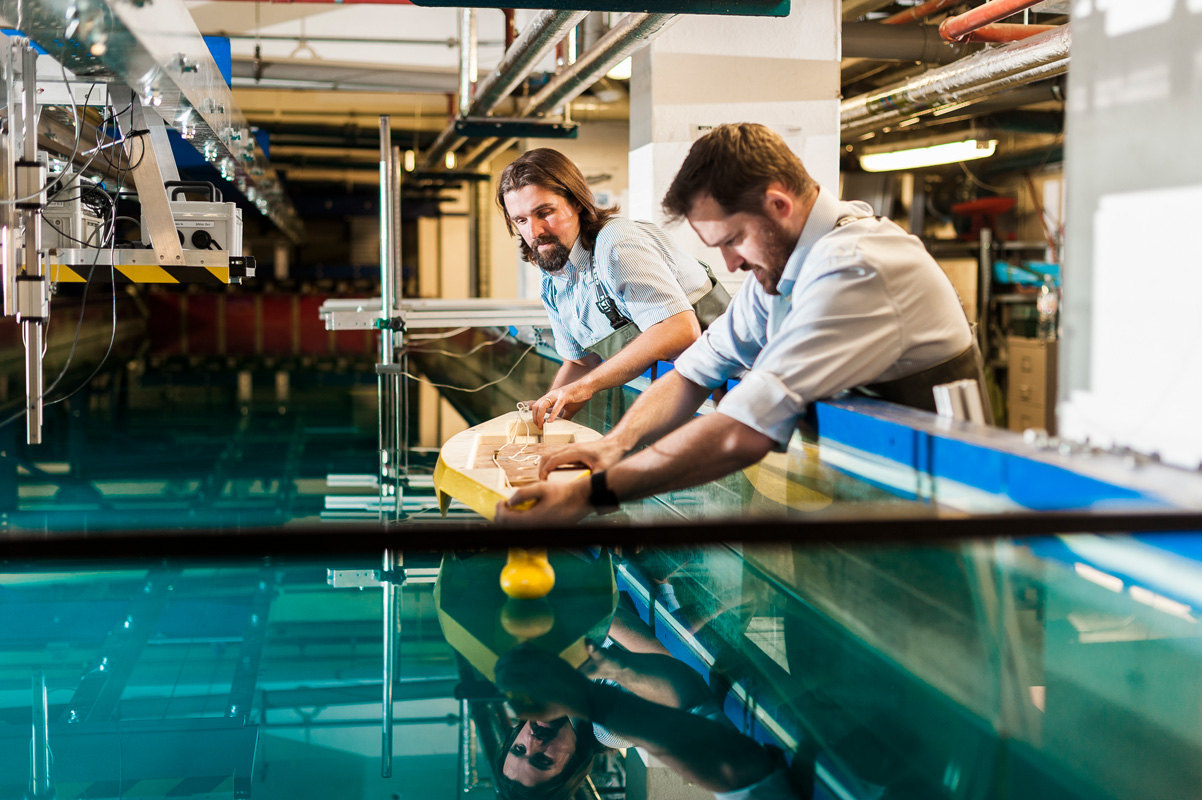 Marine Engineers conducting an experiment in an indoor tank using a model shop