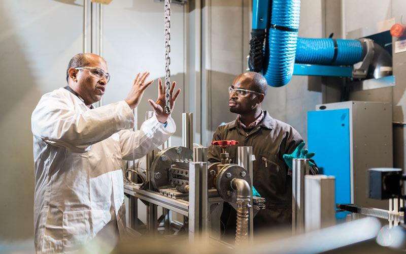 Professor Rama Balachandran explains something to a researcher in a thermofluids lab at UCL