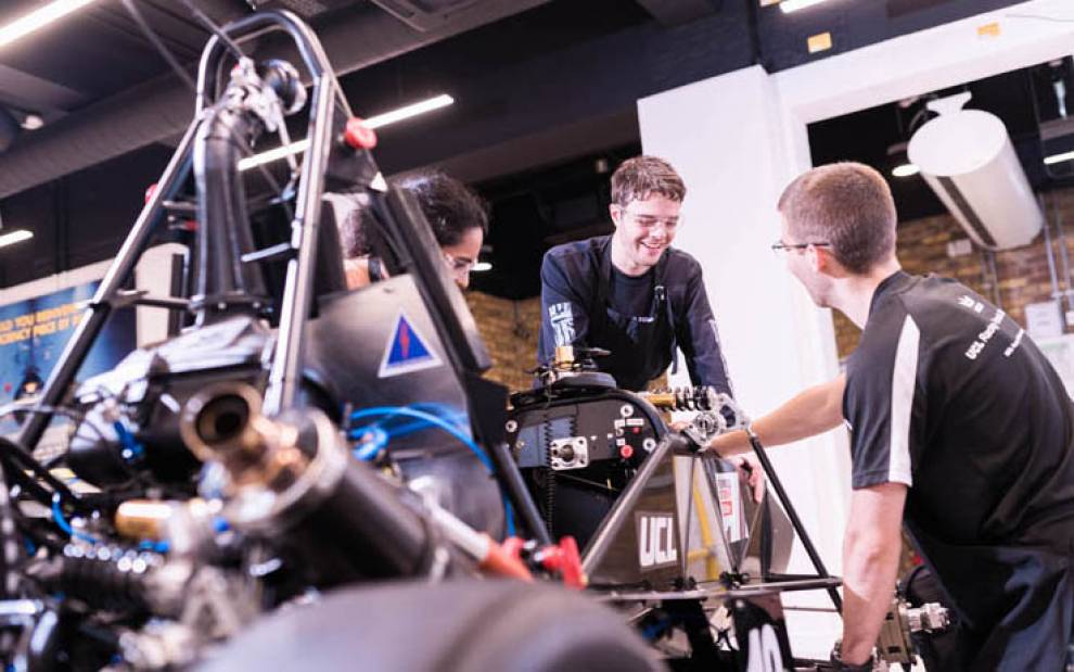 Three students building a racing car