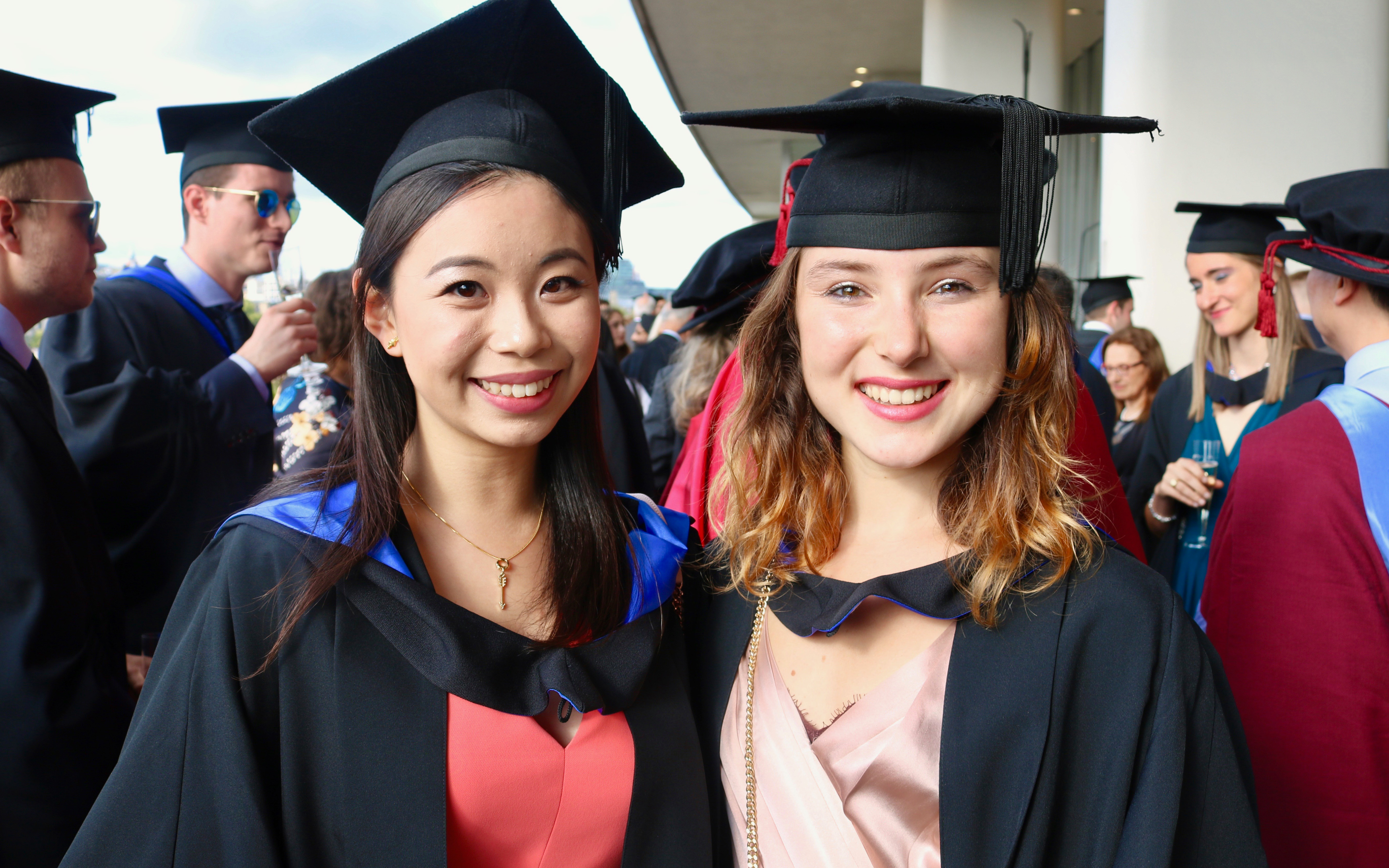 a picture of two female students in a graduation cap and gown