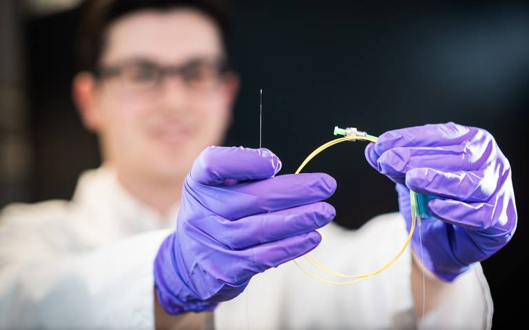 male researcher holding a fibre optic sensor 