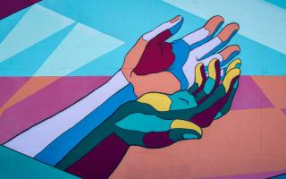 Street art depicting two hands together