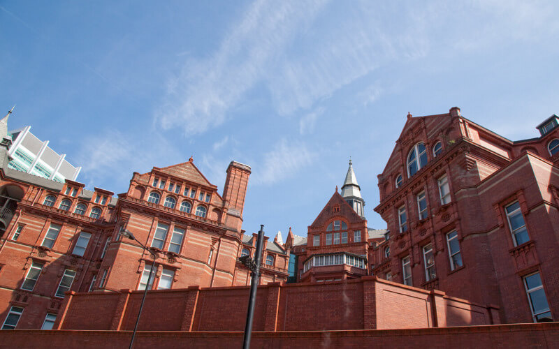 An angular shot of the UCL Cruciform Building against blue sky