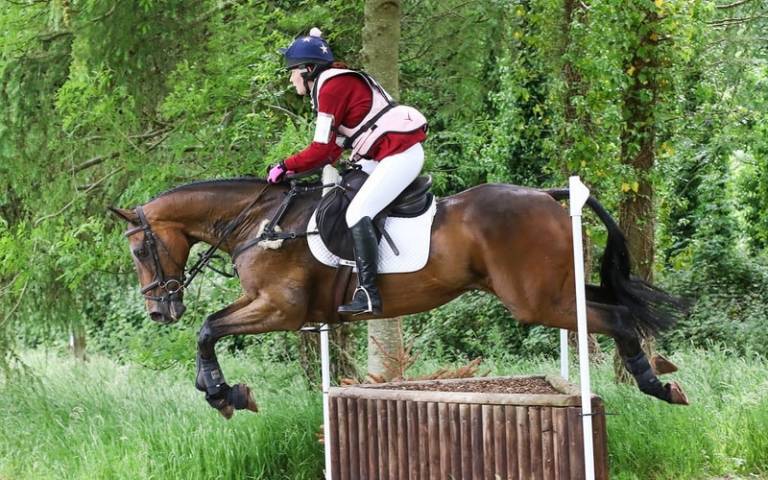 Sophie, trial patient, leaping over a barrier on a horse