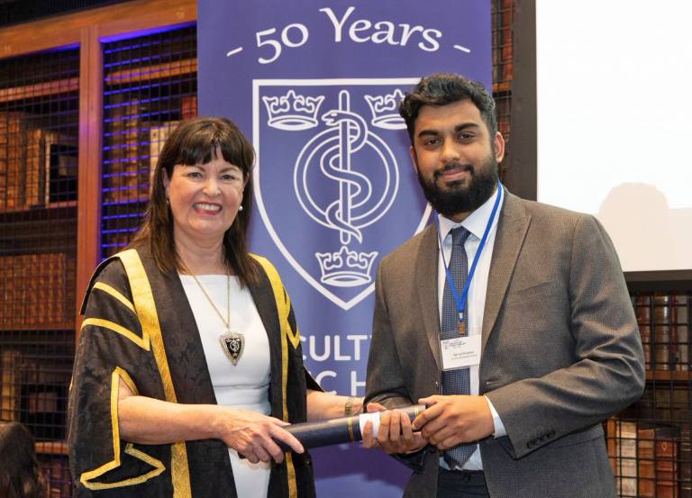 UCL Medical Student Jai Prashar receiving the Sir John Brotherston award from a representative the of Faculty of Public Health