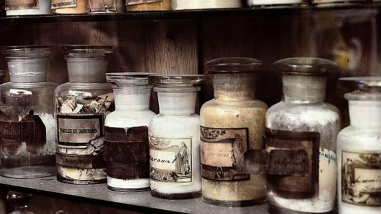 A shelf of vintage drug bottles and labels