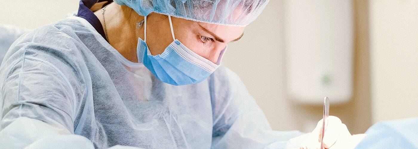 Female surgeon in mask concentrating on a procedure