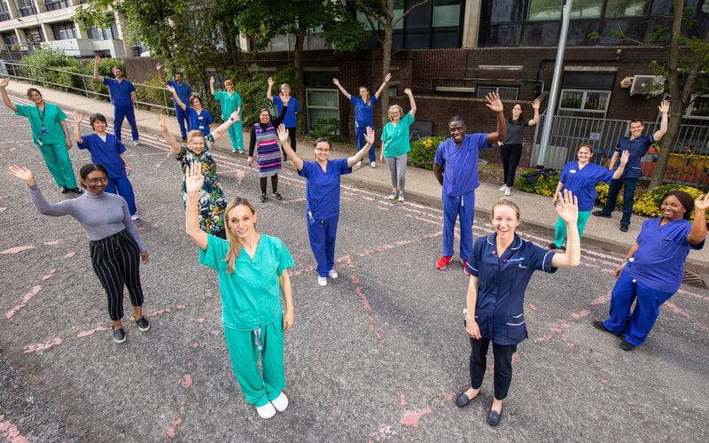 The Amyloidosis Team outside in medical scrubs, waving