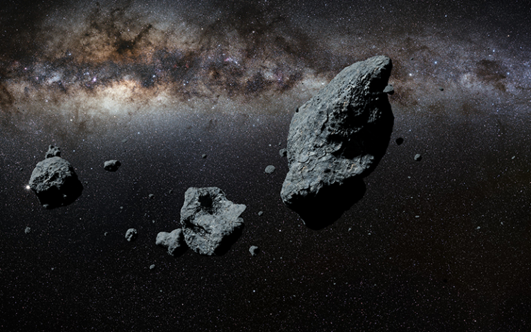 an asteroid or a meteorite flies in space, against the background of nebulae and stars