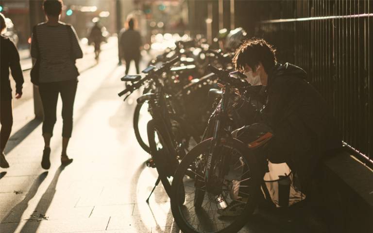 Man in black jacket in front of bicycle