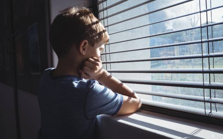 young boy looking out of a window