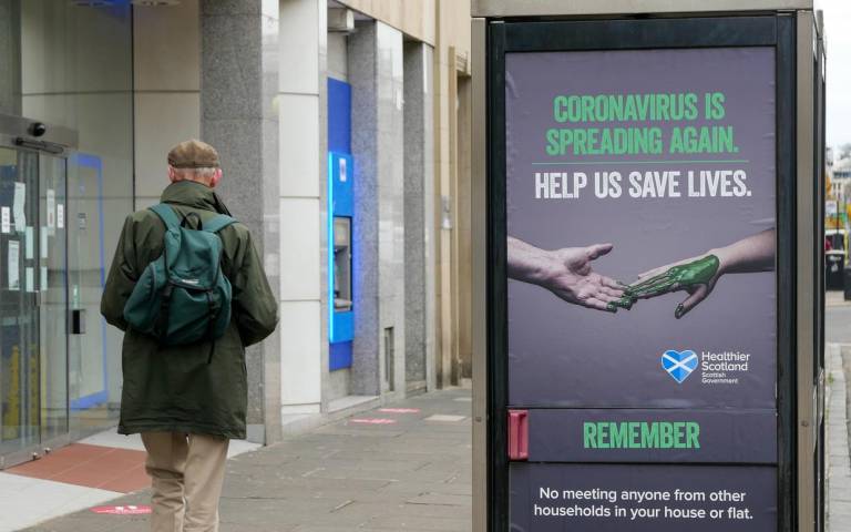 Coronavirus health warning poster on a Scottish high street. 