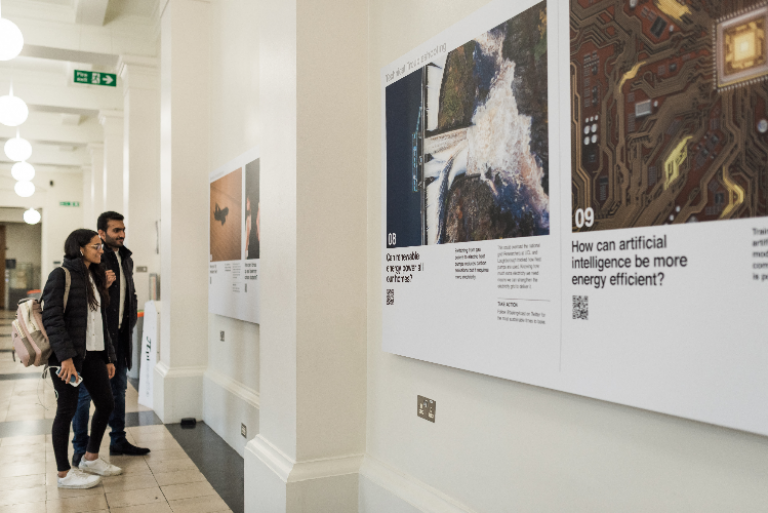 Two people look at information about climate change in an exhibition