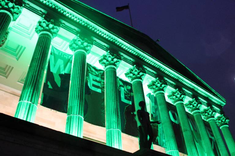 UCL portico lit up with green light at night time