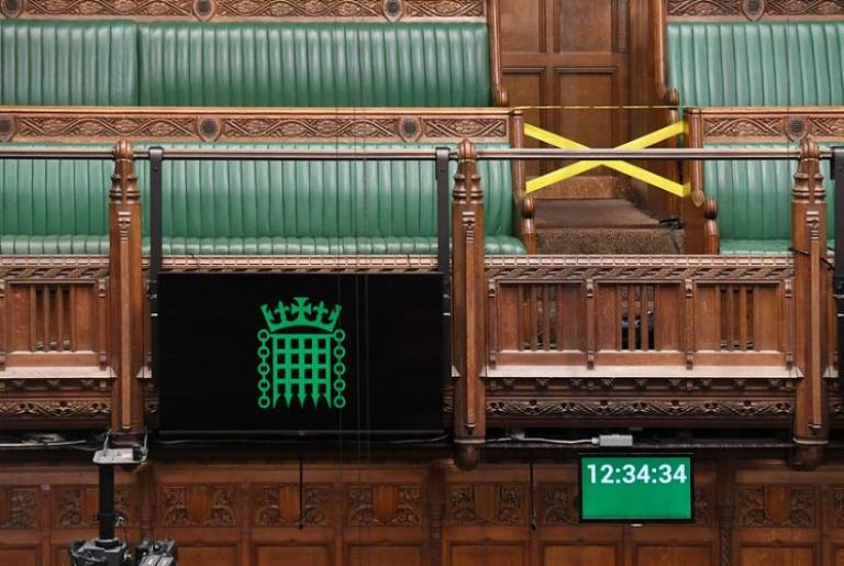 Empty House of Commons with a digital screen and seats cordoned off