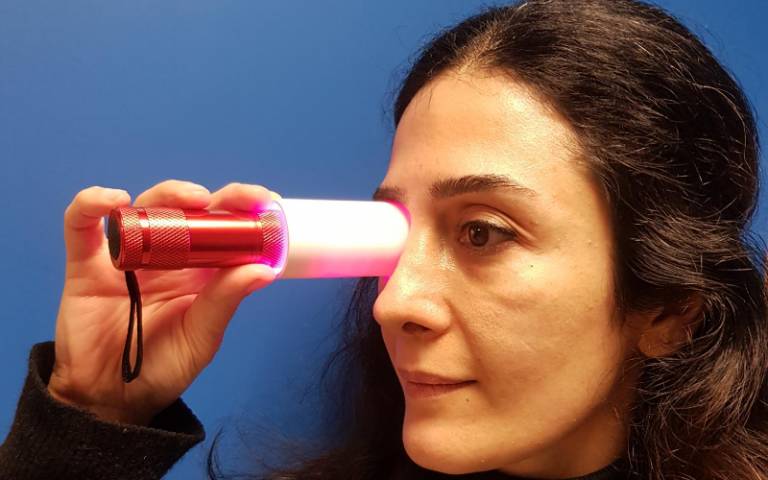 Dr Pardis Kaynezhad (UCL Institute of Ophthalmology) holds a deep red light over her eye