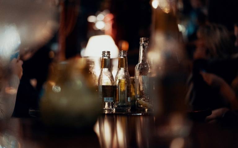 Drinks and bottles on a dimly-lit bar