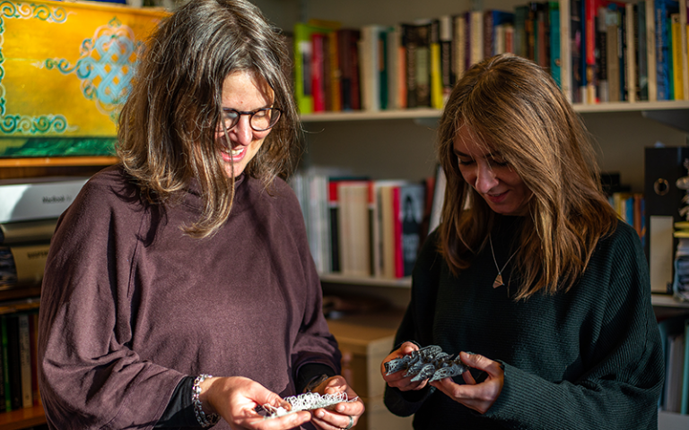 An image of Dr Pillen and Emma-Kate Mathews looking at their 3D printed models in an office 