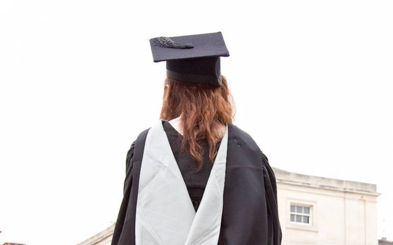Back view of a UCL graduate in graduation gown and cap
