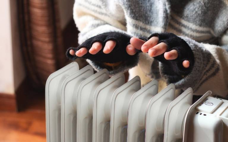 Gloved hands warming over an indoor heater