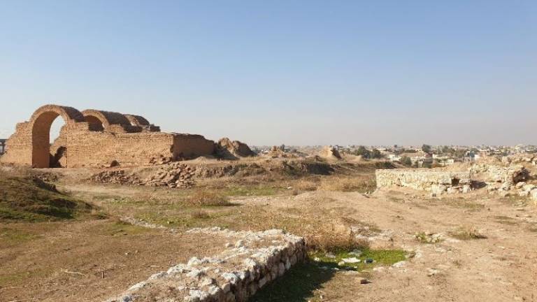 Wide shot of ruins on the outskirts of an Iraqi town in the distance