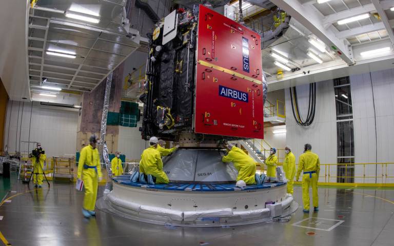 JUICE meets Ariane: ESA’s Jupiter Icy Moons Explorer (JUICE) on top of the Ariane 5 rocket that will carry it into space. Technicians are working atop the rocket, bolting down Juice’s launch vehicle adapter to keep it secure during launch. 