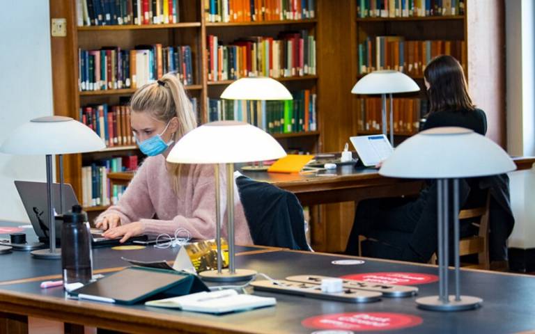 Students studying in the UCL library, socially distant and wearing face coverings