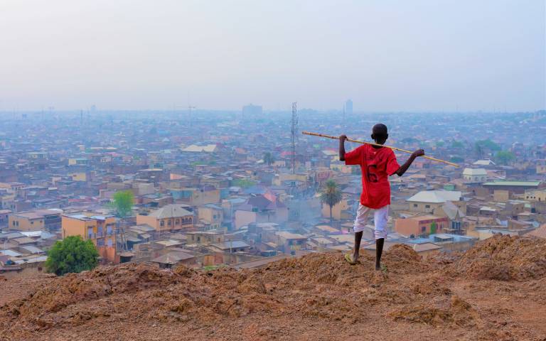 A boy looks out over city rooftops in Nigeria