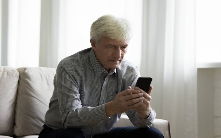 elderly single man spend free time using modern smartphone at home