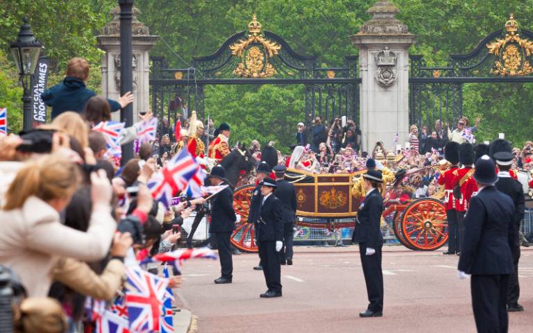 A crowd watches the royal carriage pass by during the royal wedding in 2018